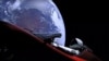 Space -- This still image taken from a SpaceX livestream video shows "Starman" sitting in SpaceX CEO Elon Musk's cherry red Tesla roadster after the Falcon Heavy rocket delivered it into orbit around the Earth on 6Feb2018.